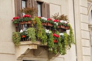Balcone piccolo con ottimizzazione verticale, fioriere appese e piante fiorite colorate